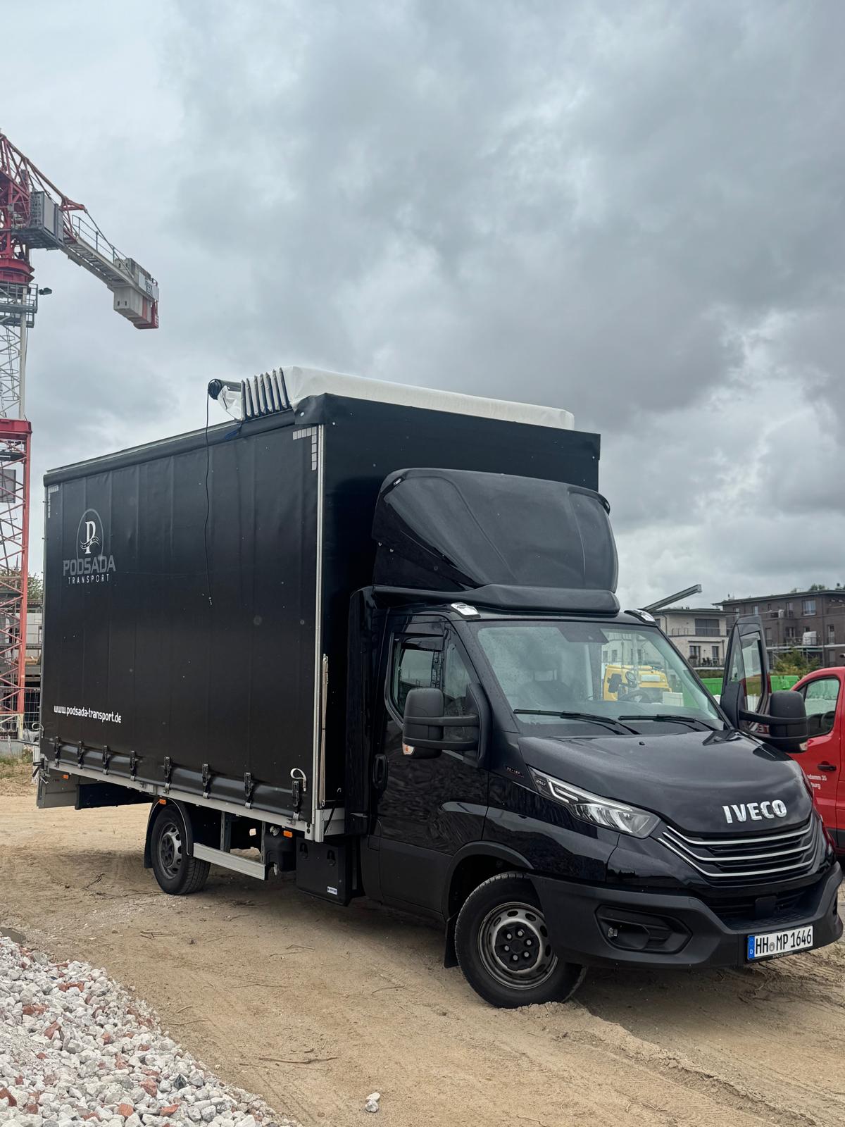 Podsada Transport IVECO truck at a construction site with a tower crane in the background