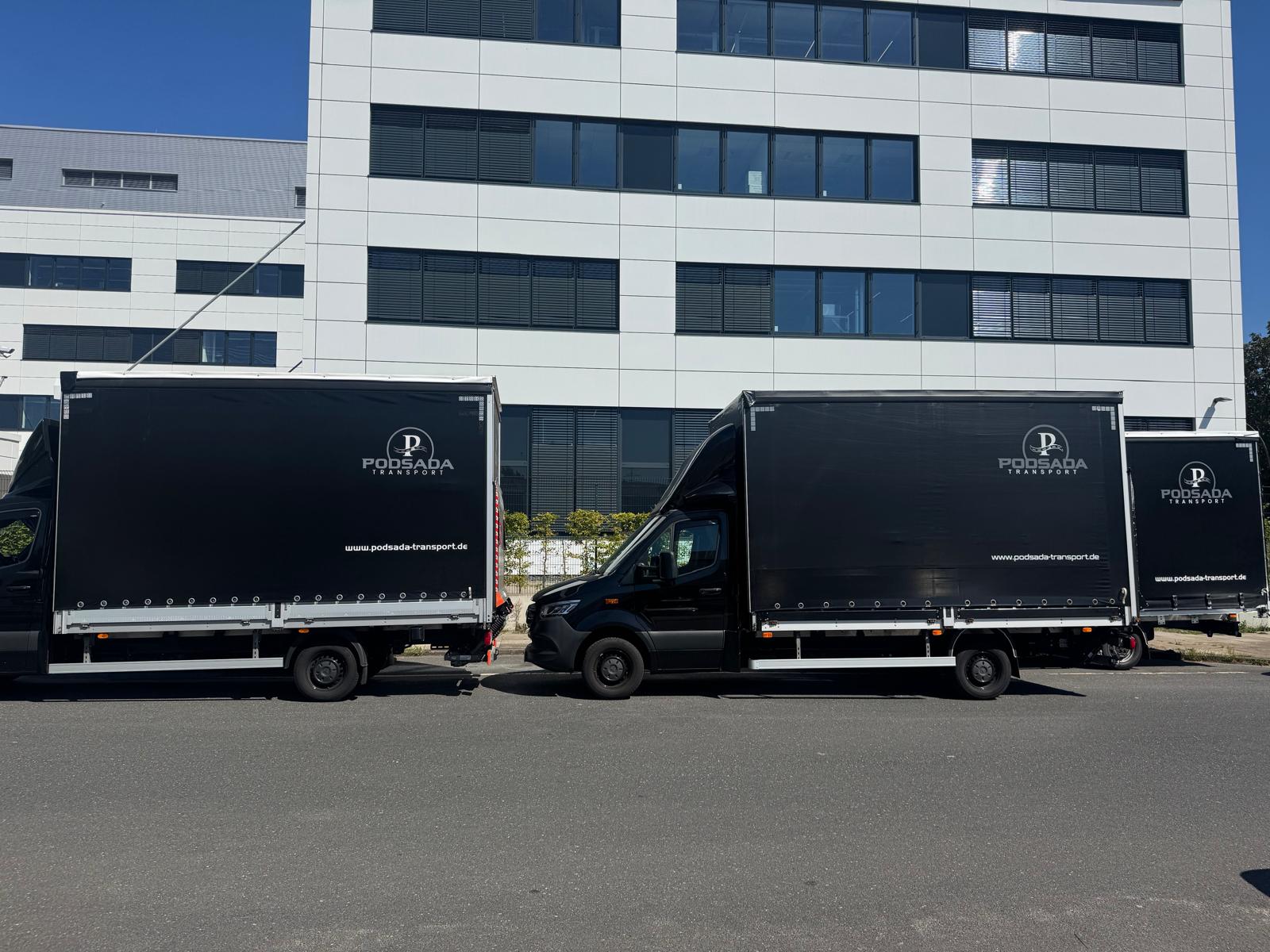 Podsada Transport truck fleet parked in front of a modern office building